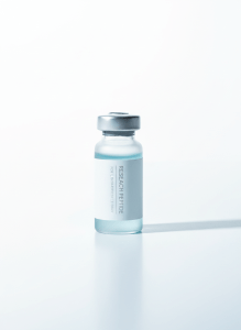 Minimalist premium research peptide product, a small frosted glass vial with clean unbranded white label standing on pure white background, soft shadow, cool silver and pale blue tones, studio product photography